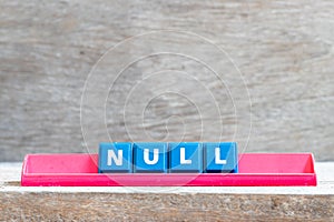 Tile letter on rack in word null on wood background