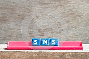 Tile letter on rack in word SNS abbreviation of Social Networking Site or sorry not sorry on wood background