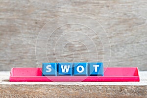 Tile letter on rack in word swot abbreviation of strength, weakness, opportunities, threats on wood background