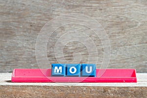 Tile letter on rack in word MOU Abbreviation of memorandum of understanding on wood background photo