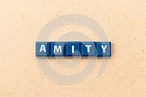 Tile letter in word amity on wood background photo