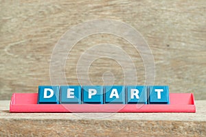 Tile letter with word depart in red color rack on wood background