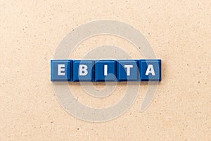 Tile letter in word EBITA abbreviation of  earnings before interest, taxes and amortization on wood background