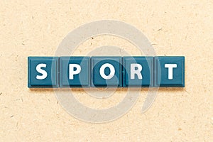 Tile letter in word sport on wood background