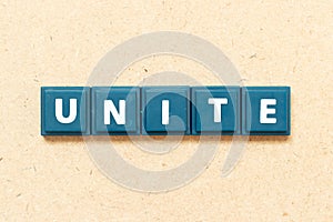 Tile letter in word unite on wood background