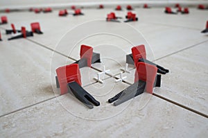 Tile levelling system with plastic clips and wedges. Close-up view