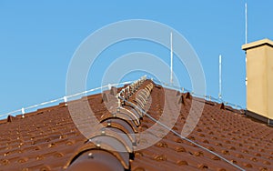 Tile roof with chimney and lightning protection system installed. Lightning rods. Close-up shot. Lightning conductor