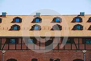 Tile roof with windows of an old brick house