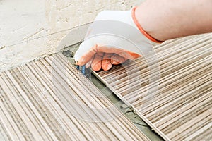 A tile`s hand places a plastic clip.