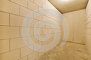 a tile wall in a room with a concrete floor