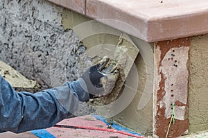 Tile Worker Applying Cement with Trowel at Pool Construction Site