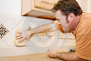 Tile Worker Wipes Grout photo