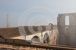 Tiled roof and incomplete facade of the planned Duomo nuovo or Facciatone in fog. Siena. Tuscany Italy.