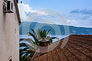 Tiled roof of an old house overlooking the sea and mountains