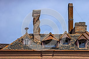 Tiled roof of an old house with skylights and chimneys