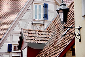Tiled roofs of 2 well-kept medieval houses with dormer and window