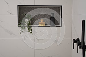 Tiled wall niche in modern bathroom.