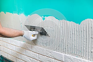 Tiler applying tile adhesive on the wall