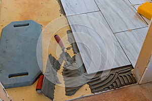 Tiler builder worker installing floor tile at repair renovation