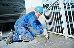 Tiler at industrial floor tiling construction or renovation