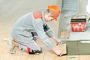 Tiler at industrial floor tiling renovation work photo