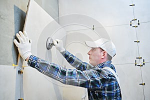 Tiler installing large format tile on wall. home indoors renovation