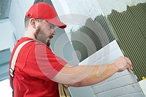 Tiler installing large size tile on wall. home indoors renovation