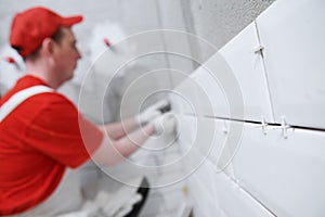 Tiler installing tile on bathroom wall. home indoors renovation