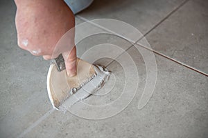 Tiler laying the ceramic tile on the floor. Professional worker makes renovation