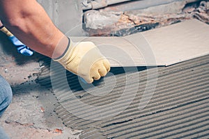 The tiler performs tile installation on the floor