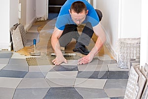 Tiler placing new floor tiles photo