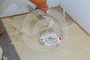 Tiler and plaster repair work laying tile, trowel in a man hand