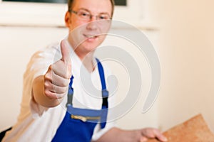 Tiler tiling tiles on the floor