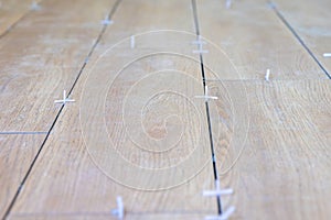 Tiler use plastic tile spacers for accurate alignment of floor tiles.