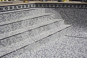 Tiles being applied to refurbish a swimming pool.