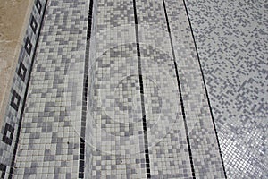 Tiles being applied to refurbish a swimming pool.