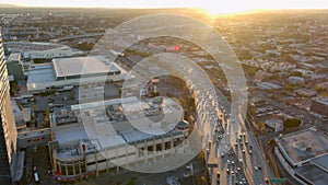 Tilt aerial footage of cars, trucks and buses driving on the 110 freeway in rush hour traffic with skyscrapers