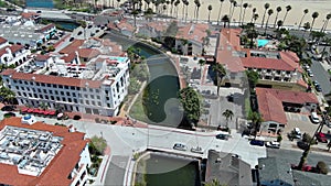 tilt aerial footage of Stearns Wharf Pier with blue ocean water, boats and yachts sailing and people relaxing in the sand