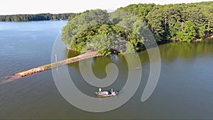 tilt aerial footage of two men in a small boat fishing in the rippling green waters of Lake Acworth