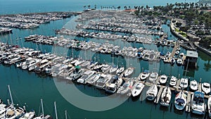 tilt aerial footage of West Beach with boats and yachts docked in the marina, cars driving on the street