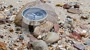 Tilt close up shot of the compass on the rock and sand beach with nature sea ambient sound