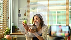 Tilt down shot of female nutritionist or healthy food blogger recording video blog on smartphone. Wellness and healthy