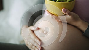 Tilt down video of pregnant woman eating fruits