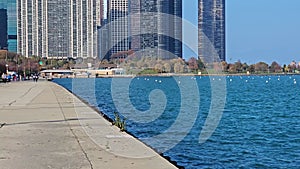 tilt footage of a skyscrapers, hotels and office buildings in the city skyline at Lakefront Park on the banks of Lake Michigan