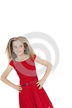 Tilt image of girl wearing red frock looking sideways with hands on hips over white background