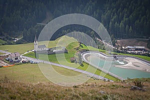 Tilt shift effect of alpine church and small lake, Alto Adige, Italy