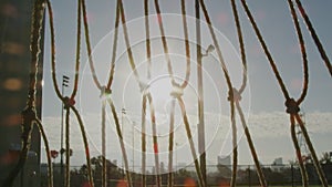 Tilt up of bungees on soccer net on a field with beautiful sunlight