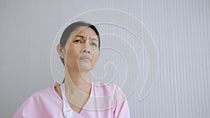 Tilt up footage video of An elderly female patient in the hospital sitting absent-minded and contemplating, concept of health care