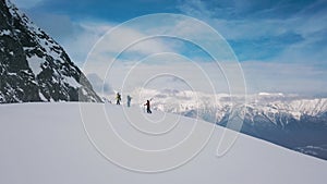 Tilt up group active backpacker travelers with snowboarding and skiing climbing on top of mountain