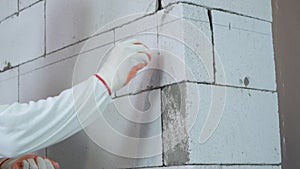 Tilt up shot of worker inserting dowels into holes drilled in block wall